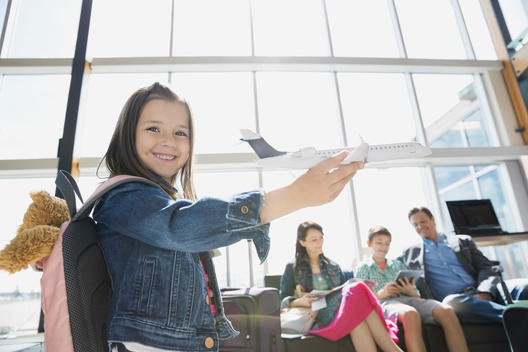 Girl playing with toy airplane in airport