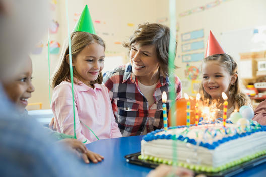 Teacher with kids celebrating birthday in elementary school