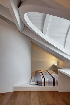 Recessed single bed under beamed ceiling with arched dormer in Apartment Garegnani, Nerviano, Milan, Italy.