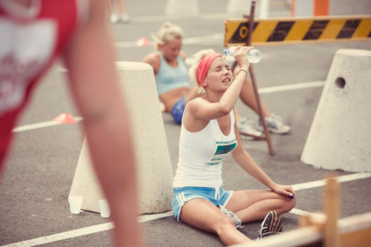 Female long distance runner refreshing with water