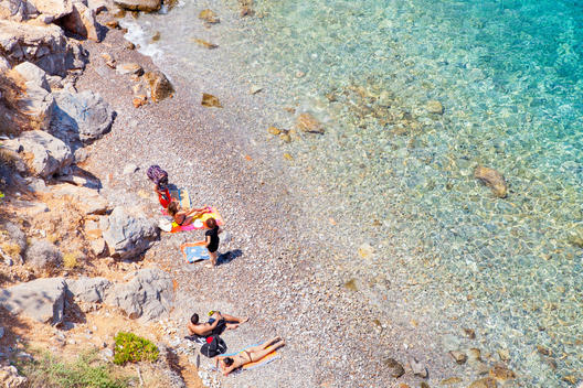 Sun bathers on pebbled beach