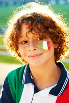 closeup portrait face of a boy with italian flag painted on his cheek