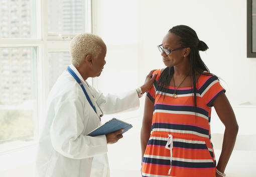 Black doctor talking with patient
