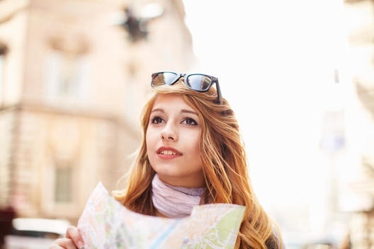 Young woman with street map looking lost, Rome, Italy