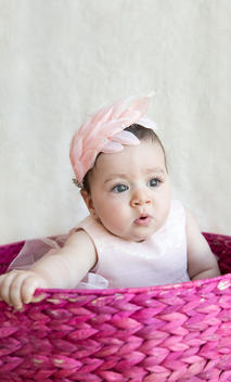 Little infant wearing pink inside a pink basket