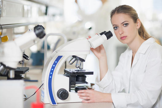 Caucasian scientist using microscope in lab