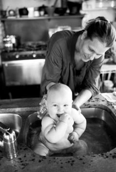 Mother Giving Baby Bath In Sink