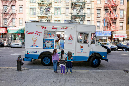 Three girls in front of ice cream truck in the Chinatown street, New York City, New York, United States of America.