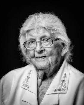 Black and white portrait of elderly woman wearing glasses with white hair