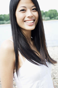 Germany, Close up of young woman at Rhine riverside, portrait, smiling