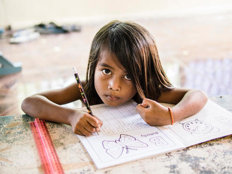 A girl does schoolwork at The Wat Opot Community, an orphanage for children affected by HIV and AIDS, near Chambak, Cambodia, outside Phnom Penh.