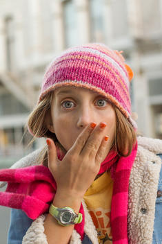 girl wearing pink hat with hand over mouth