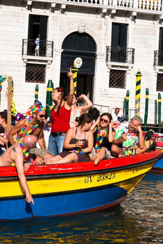 People partying on a colorful canal boat on the Grand Canal in Venice, Italy.