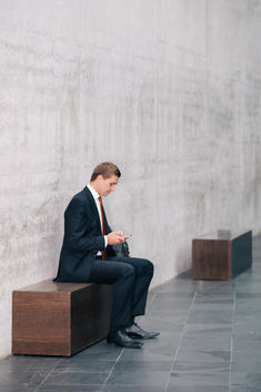 Portrait of young business consultant checking his smartphone