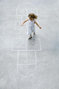 Little girl playing hopscotch, high angle view