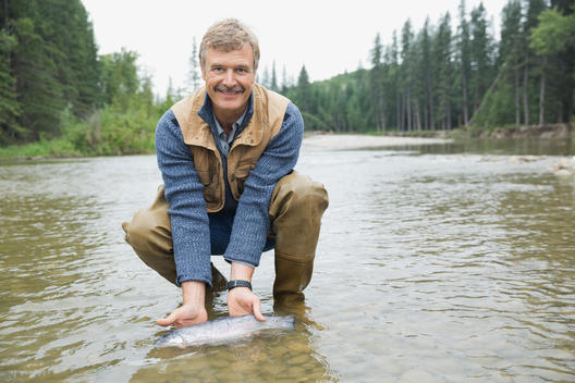 Portrait of mature man holding caught fish