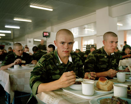 Young Russian Soldiers Eat Lunch In The Canteen Of The Kovrov Army Training Camp. Soldiers Eat A Meal Of “Milk Soup”, Oatmeal Porridge With Chunks Of Meat And Beet Salad.