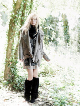 Fashion Story Model With Blonde Hair Standing In An Enchanted Forest With Lots Of Soft Backlight
