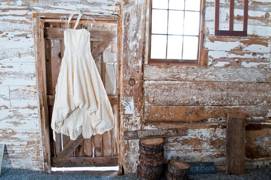 Rustic barn, farm wedding shoot, dress hanging in doorway of old barn