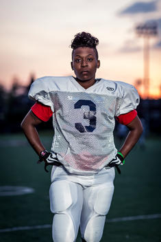 Portrait of a women\'s football player on the field during an evening practice.