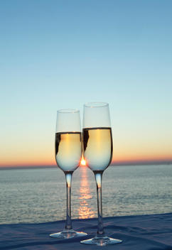 Two champagne flutes against sunset