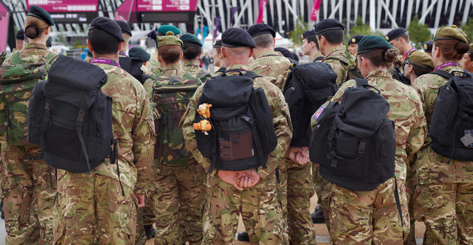 British soldiers drafted in to help security at the Olympic Park after the failure of G4S to supply enough staff. One solider has a Tigger toy attached to the back of his rucksack. Stratford, London. 2012 London Olympics.