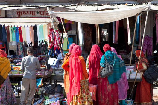 Indian women wearing sari and shopping at a market stall