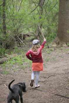 Young Girl Leading Her Dog Down A Path Like A Marching Band Troop Leader In The Woods Amongst Nature