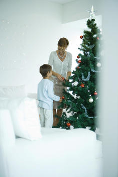Boy and mother decorating Christmas tree
