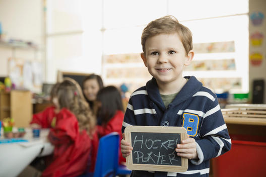 Elementary boy holding slate with \
