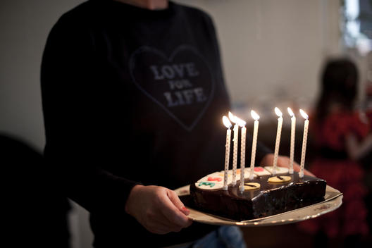 A mother with an anniversary cake and candles