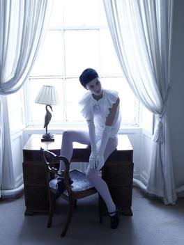 Fashion Story Model In A White Outfit In Front Of Large Window With Lots Of Back Light
