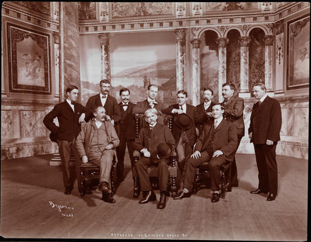 Group Portrait Of The Production Staff Of The Savage Opera Company, Pictured On Stage Before The Painted Backdrop Of An Unidentified Production.