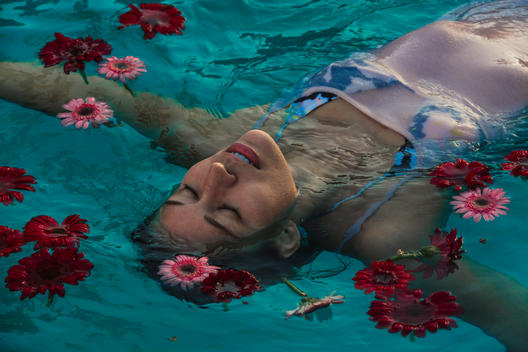 Girl floating in water with flowers