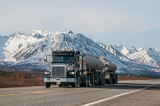 Truck hauling oil on a highway in Alaska.