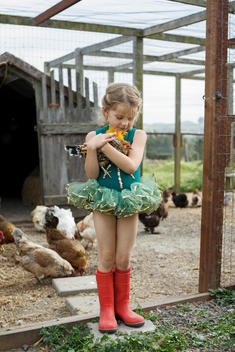 Young girl in tutu holding chicken