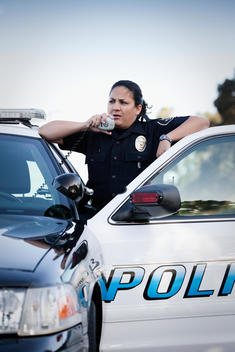 Hispanic policewoman talking on CB radio