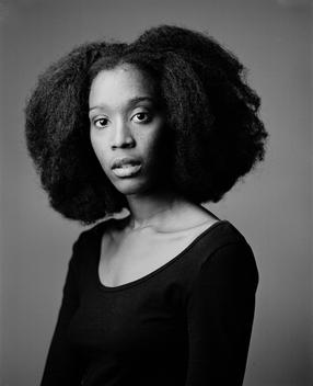 Classic black and white studio portrait of Fanta, a young black, African woman with an afro. Brooklyn, NYC