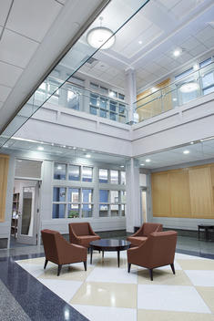 Commercial interior entery way with woods walls, granite floors and glass doors.