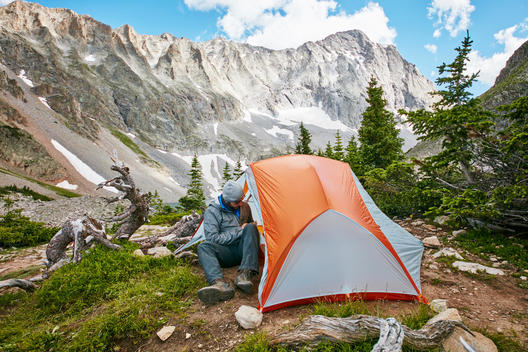 A man setting up his camp high in the mountains