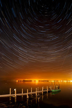 Germany, View of startrails above old jetty at night