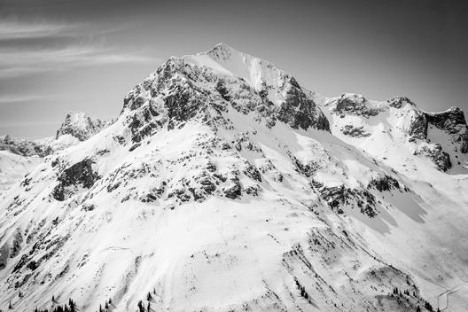 Close up of a snowy landscape with steep mountain peaks, black & white