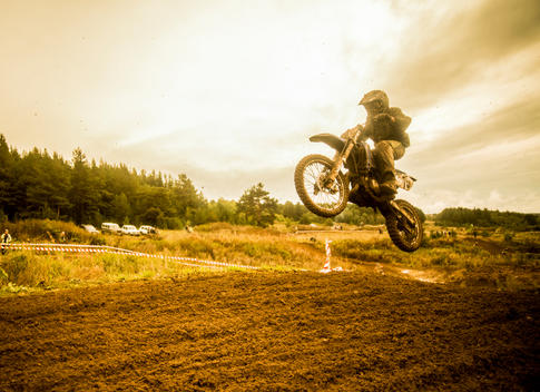 Boy mid air on motorcycle at motocross