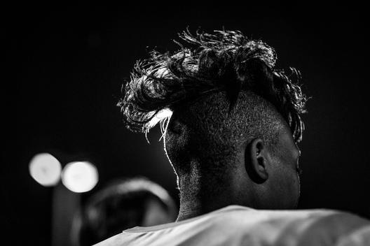 Black and white view of a women\'s football players hair during a nighttime practice.