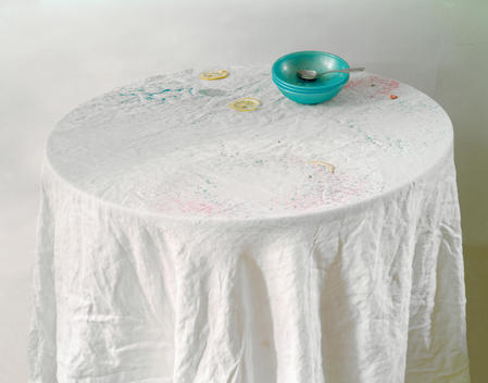 Round White Tablecloth On White Wall With Blue Plastic Bowls, Spoon, Littered Fruit Slices