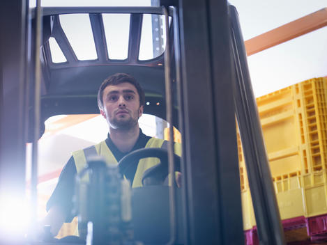 Apprentice drives forklift truck in training facility