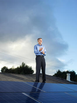 Founder of SolarCity, Lyndon Rive, stands on top of a roof covered in solar panels