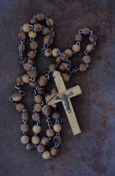 Rosary with crucifix lying on rusty metal sheet
