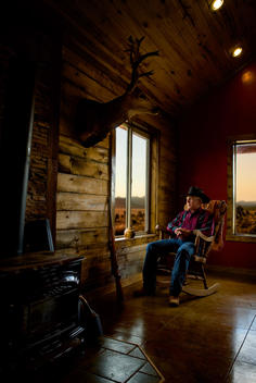 Cowboy sitting in front of window with his rifle