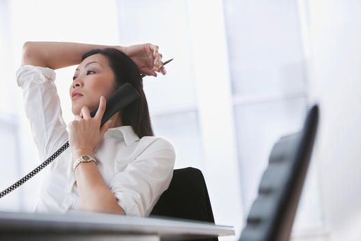 Chinese businesswoman using telephone in office